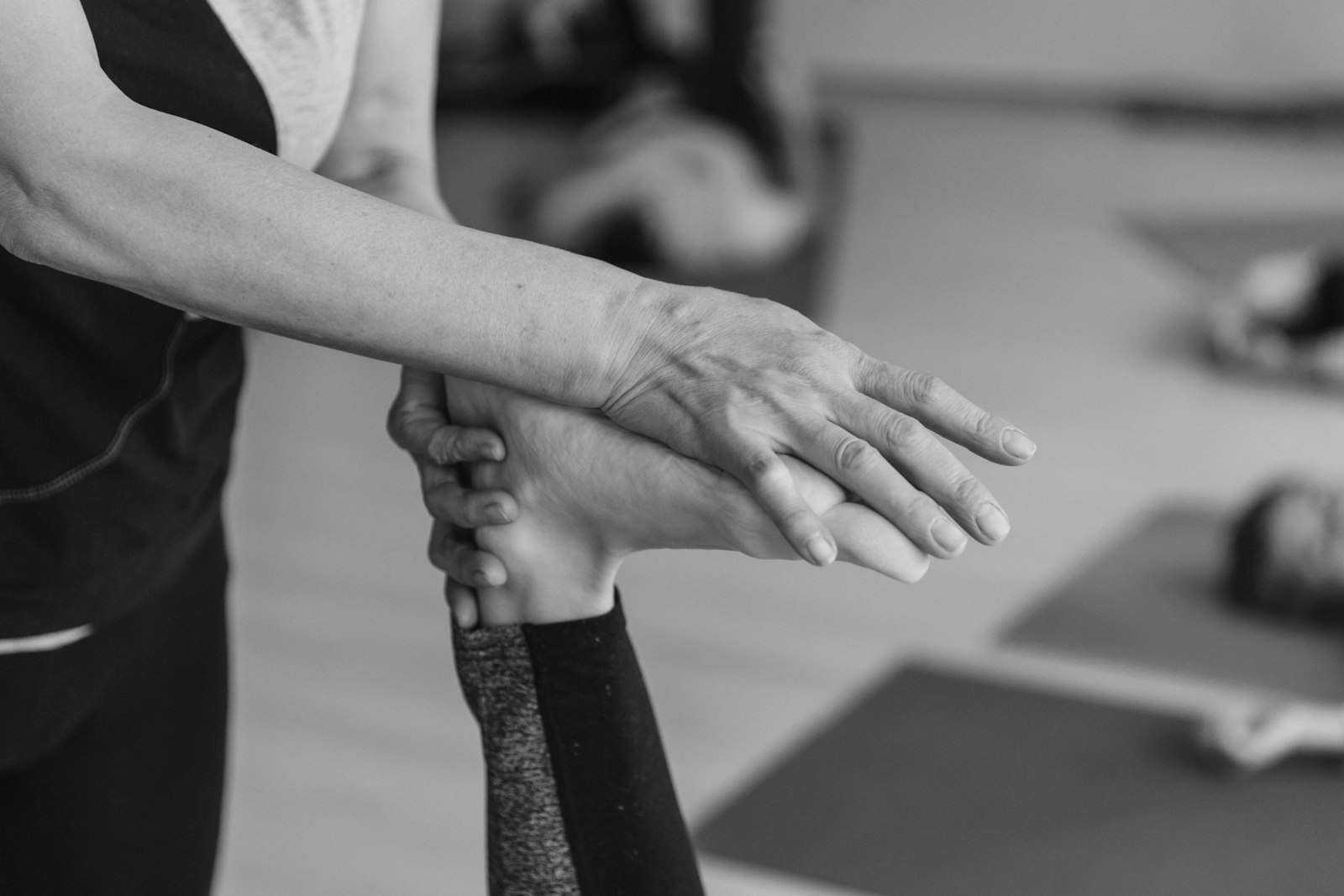Terapeuta sosteniendo y guiando el brazo de una persona durante un ejercicio
